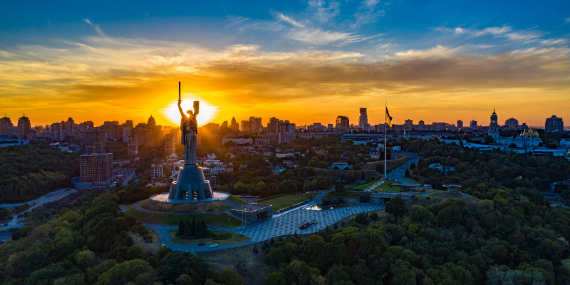 Aerial view to the Motherland statue in the Kiev while  summer sunset. The well-known landmarks in Kyiv. Historical monument of Soviet union. Beautiful city Kiev while sunset.